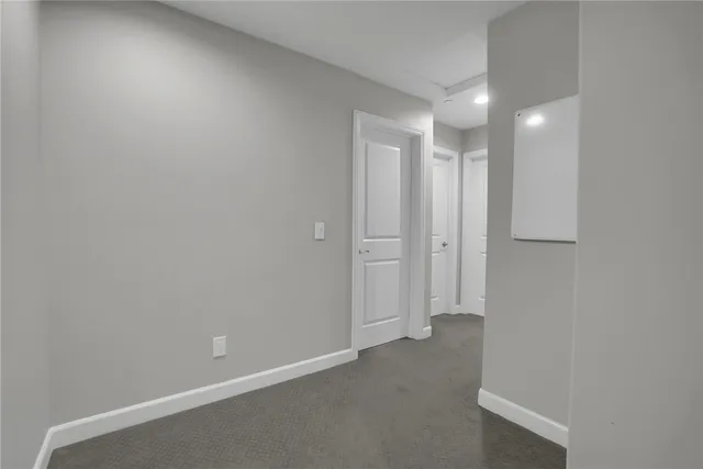 an empty room with closet and windows