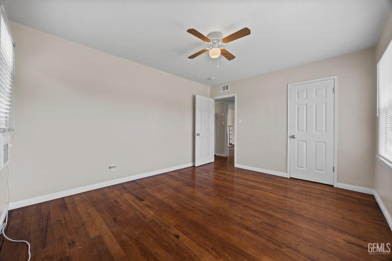 Undisclosed Address Bakersfield, CA 93305 - Photo 19 of 29 an empty room with wooden floor and ceiling fan