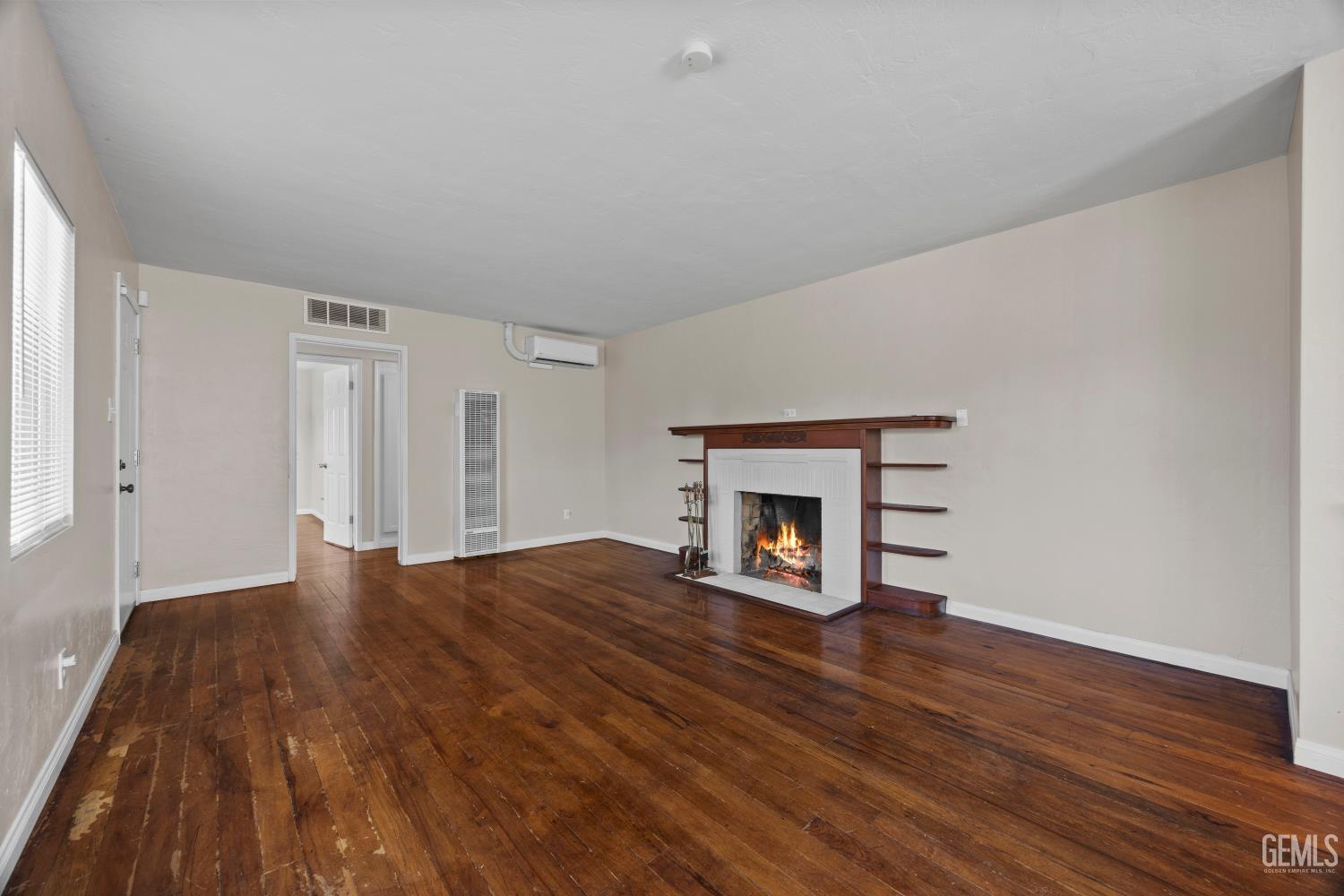 Undisclosed Address Bakersfield, CA 93305 - Photo 6 of 29 a view of an empty room with wooden floor fireplace and a window