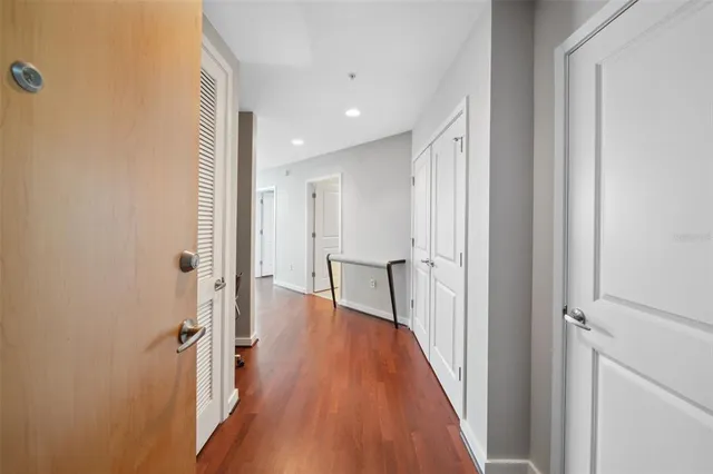 a view of a hallway with wooden floor and a living room