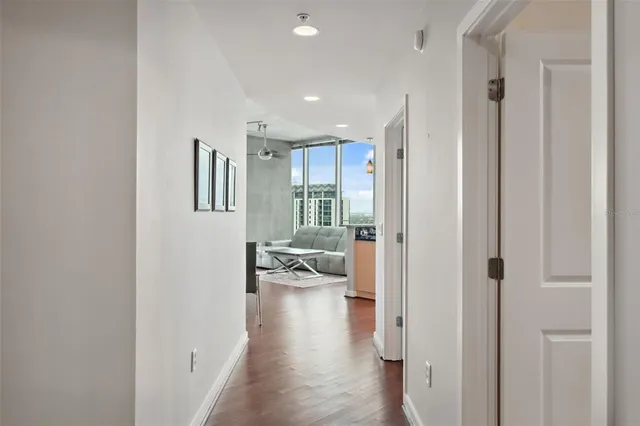 a view of hallway with wooden floor and cabinets
