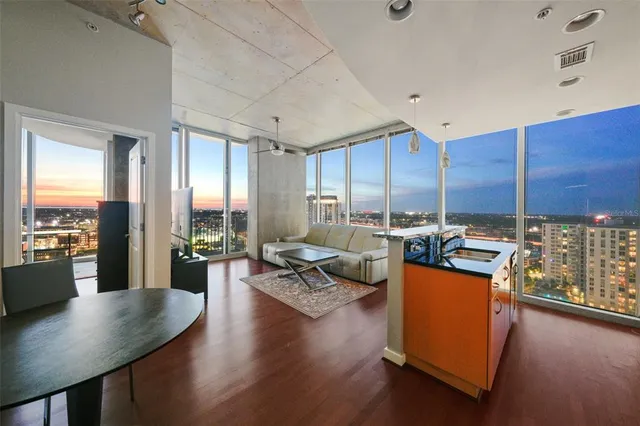 a living room with furniture and a view of kitchen