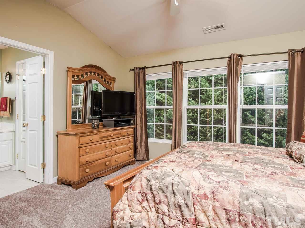 8514 Bright Loop Raleigh, NC 27613 - Photo 12 of 20 a large bedroom with a bed and a large window