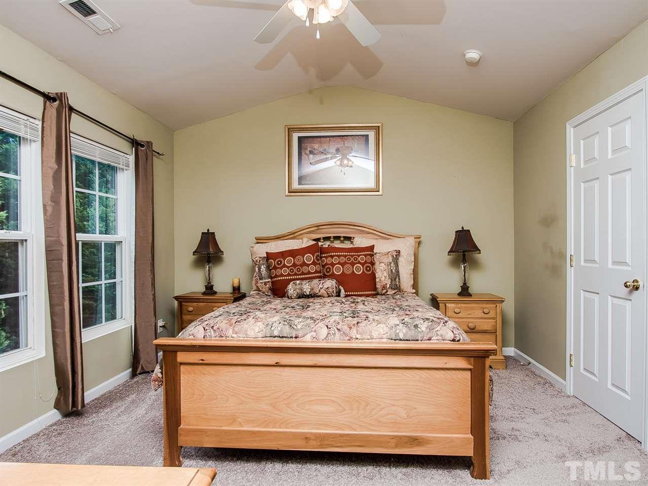 8514 Bright Loop Raleigh, NC 27613 - Photo 13 of 20 a bedroom with a bed and wooden floor
