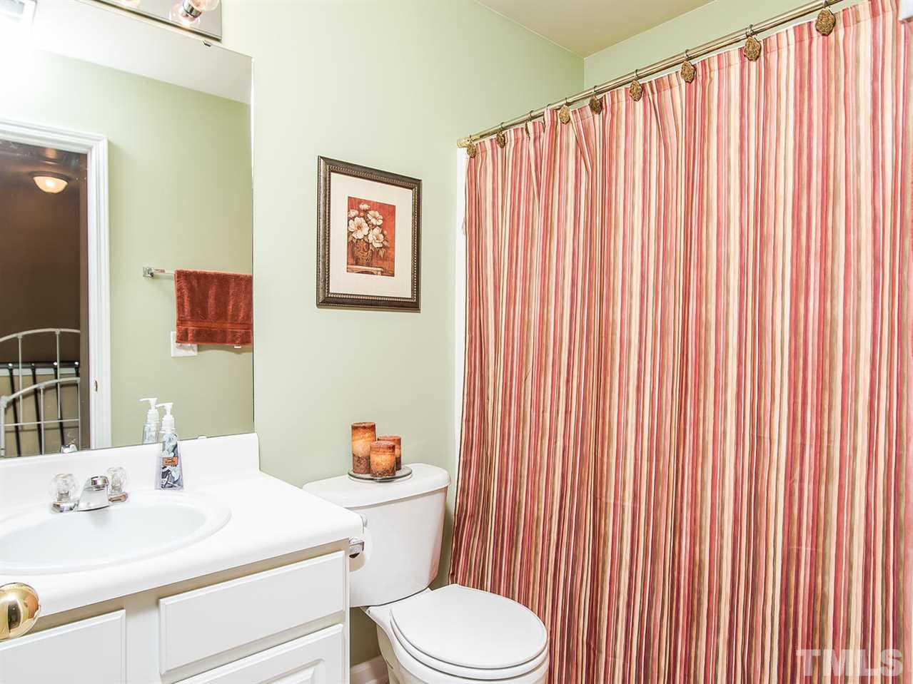 8514 Bright Loop Raleigh, NC 27613 - Photo 17 of 20 a bathroom with a sink a toilet and shower curtain