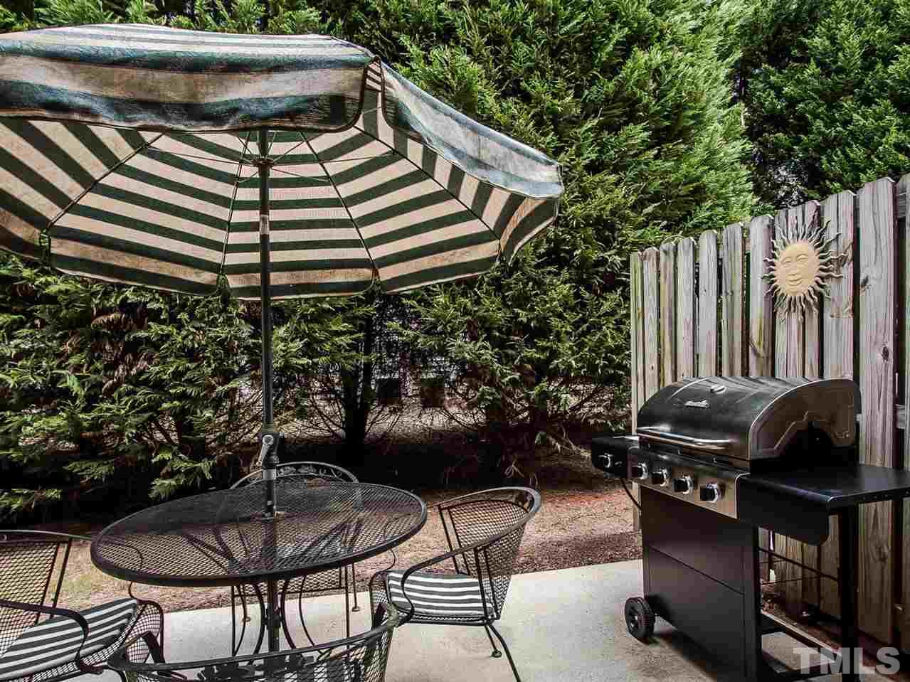 8514 Bright Loop Raleigh, NC 27613 - Photo 19 of 20 a backyard of a house with barbeque oven and outdoor seating