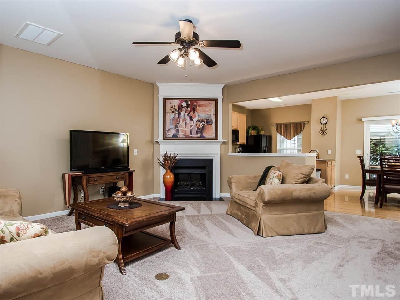 8514 Bright Loop Raleigh, NC 27613 - Photo 4 of 20 a living room with furniture a flat screen tv and a fireplace