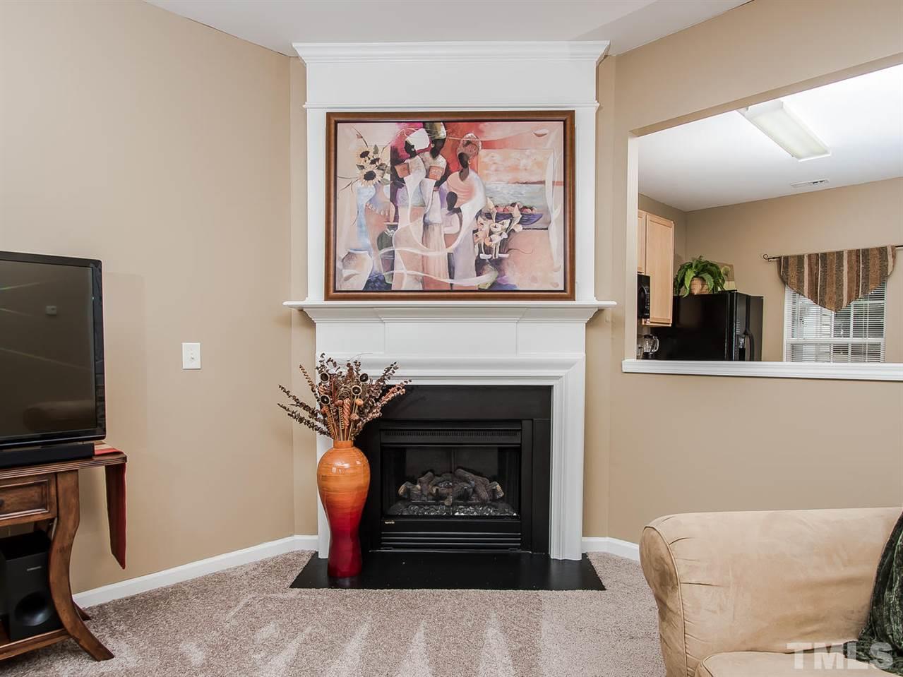 8514 Bright Loop Raleigh, NC 27613 - Photo 6 of 20 a living room with furniture a flat screen tv and a fireplace