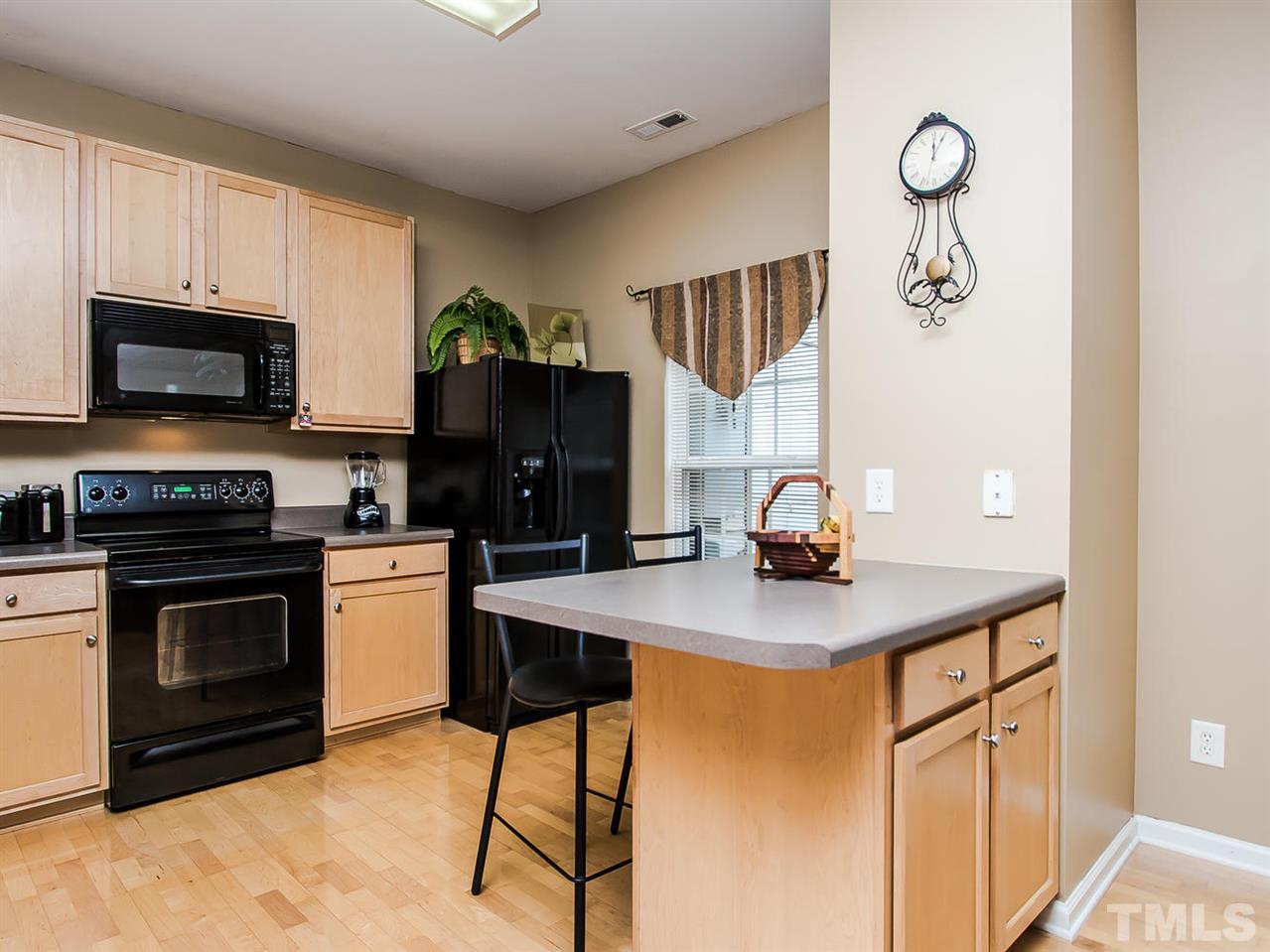 8514 Bright Loop Raleigh, NC 27613 - Photo 7 of 20 a kitchen with stainless steel appliances granite countertop a stove top oven a sink a counter space and cabinets