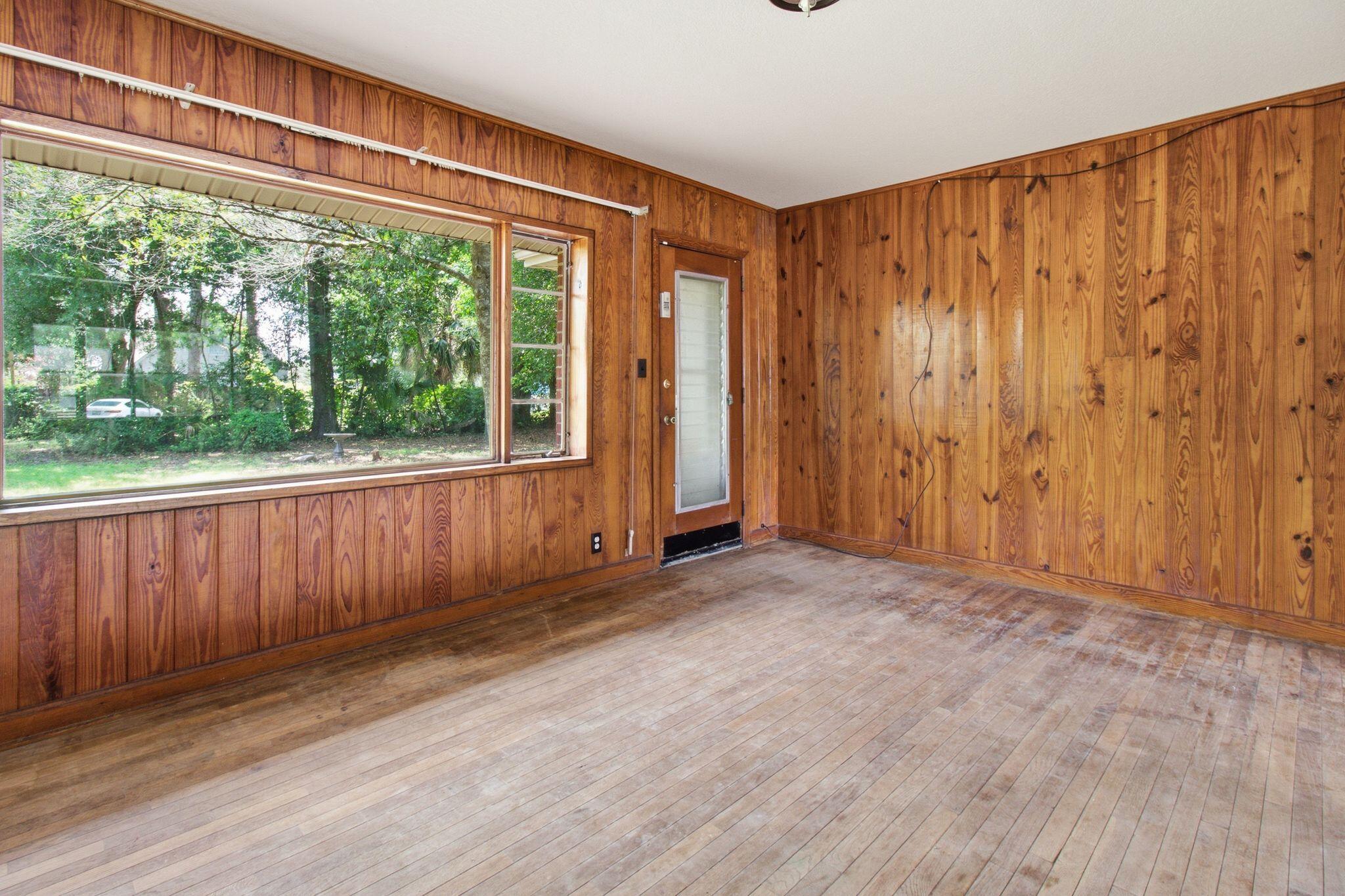 855 North Pearl Street Crestview, FL 32536 - Photo 5 of 31 a view of an empty room with wooden floor and a window