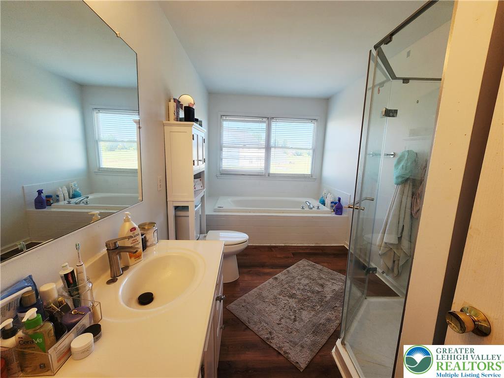 237 Ridings Circle Macungie, PA 18062 - Photo 37 of 70 Rich wood-inspired flooring pairs with a soaking tub and separate glass-enclosed shower.