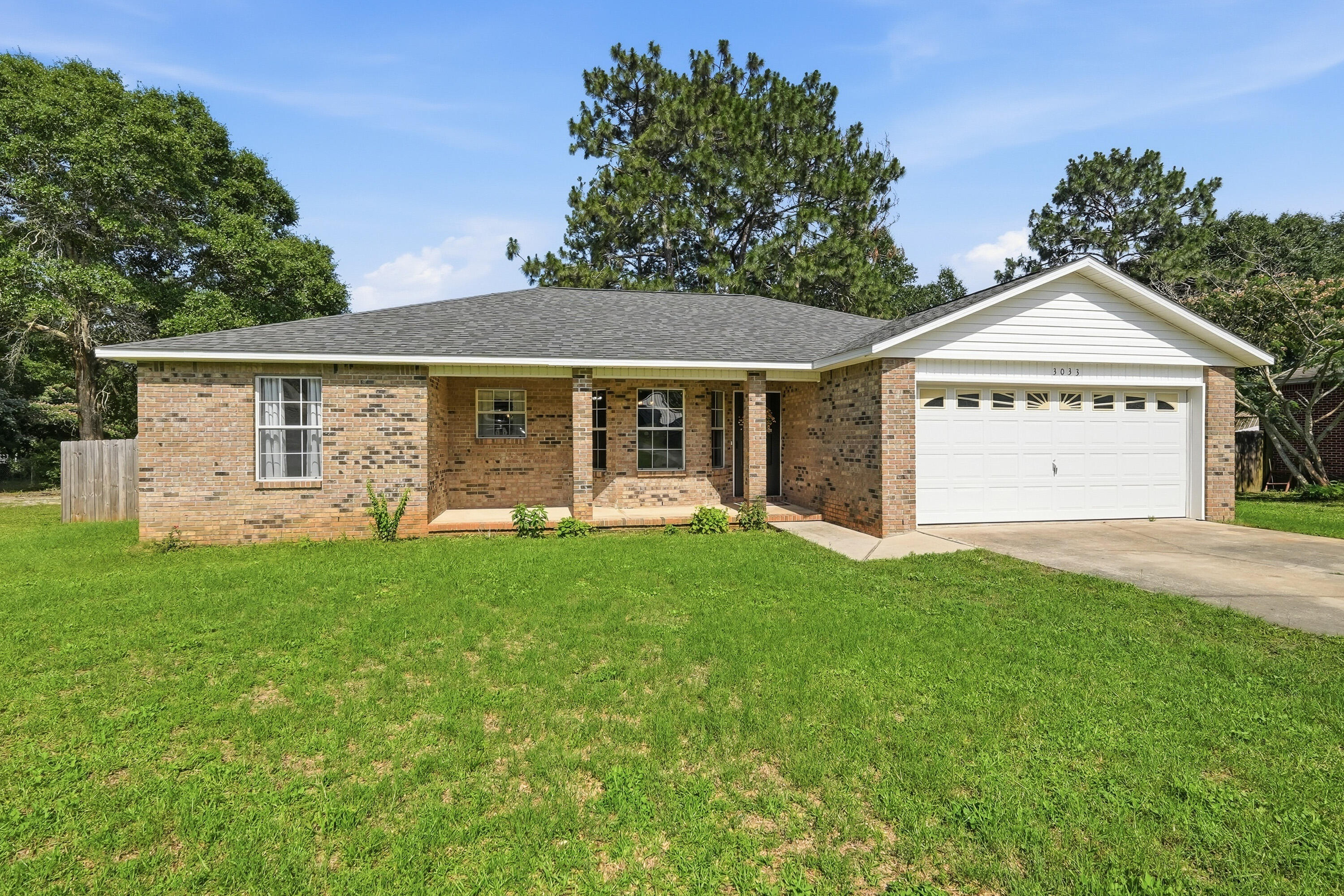 3033 Cabela Lane Crestview, FL 32539 - Photo 26 of 32 a view of a house with a yard potted plants and large tree