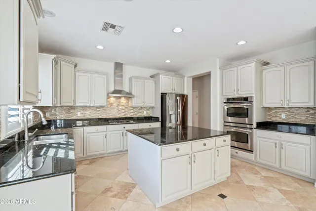 a kitchen with stainless steel appliances granite countertop a stove a sink and a refrigerator
