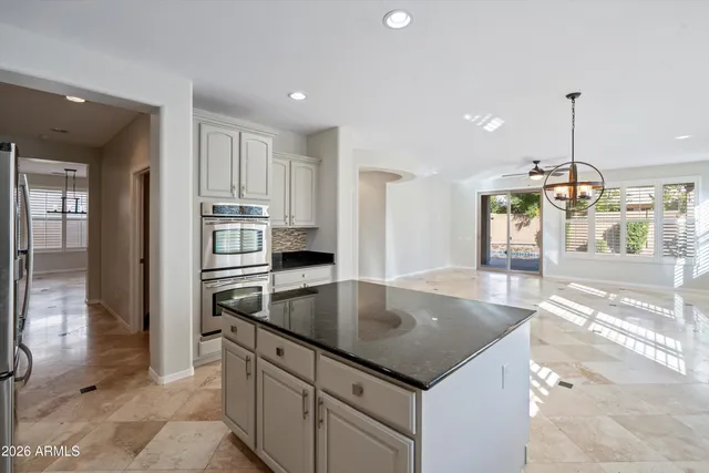 a kitchen with stainless steel appliances granite countertop a sink a stove and a refrigerator