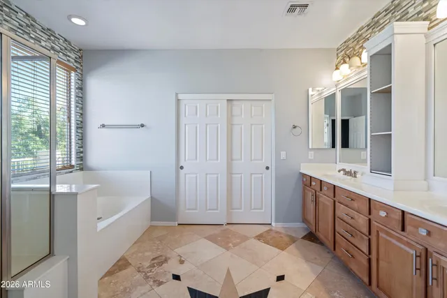 a bathroom with a double vanity sink and mirror with shower