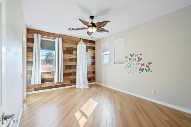 a view of an empty room with window and wooden floor