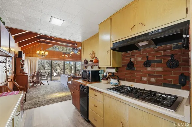 a kitchen with stainless steel appliances granite countertop a stove a sink and a dining table view