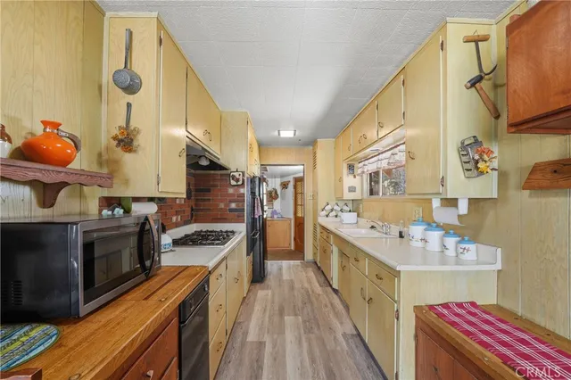 a kitchen with stainless steel appliances a stove a sink and a refrigerator