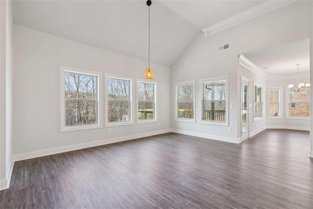 1833 Millstone Manor Conyers, GA 30013 - Photo 11 of 50 a view of an empty room with wooden floor and a window