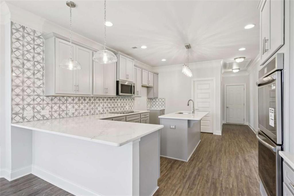 1833 Millstone Manor Conyers, GA 30013 - Photo 16 of 50 a large white kitchen with a sink a refrigerator and a stove