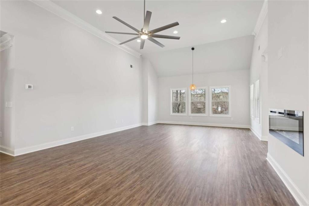 1833 Millstone Manor Conyers, GA 30013 - Photo 7 of 50 an empty room with wooden floor chandelier fan and windows
