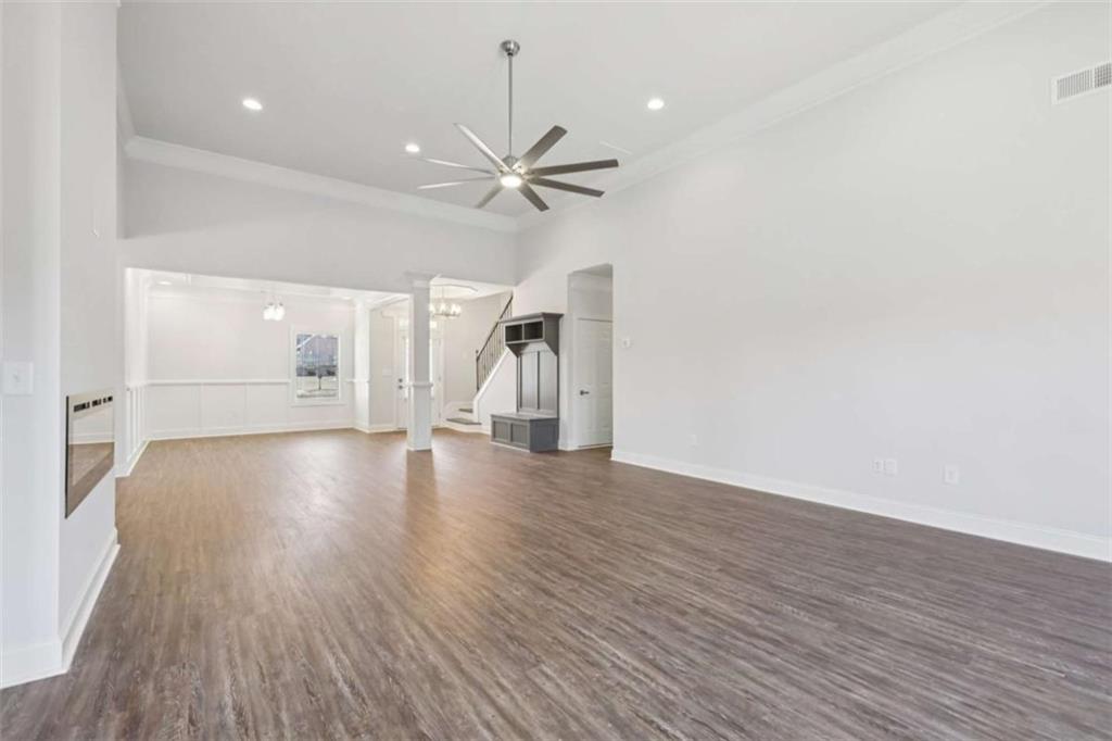1833 Millstone Manor Conyers, GA 30013 - Photo 8 of 50 a view of an empty room with wooden floor and a ceiling fan