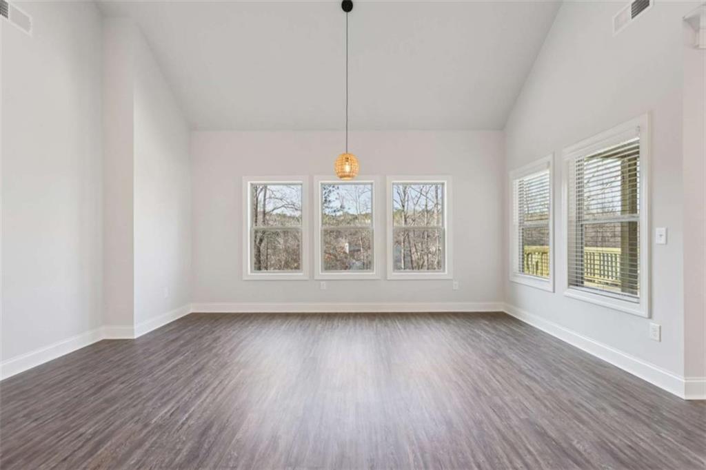 1833 Millstone Manor Conyers, GA 30013 - Photo 10 of 50 a view of an empty room with wooden floor and a window