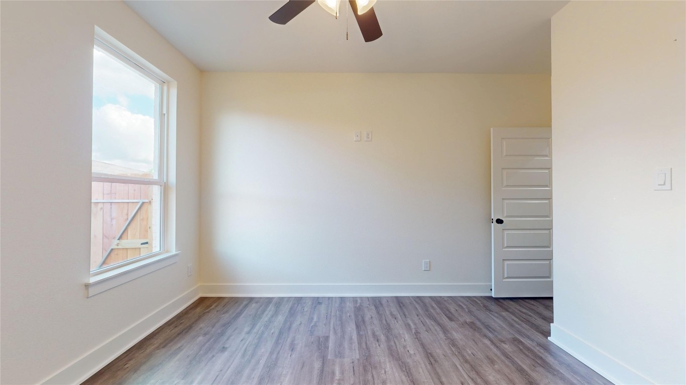 5119 Selinsky Road Houston, TX 77048 - Photo 18 of 45 an empty room with wooden floor cabinet and windows