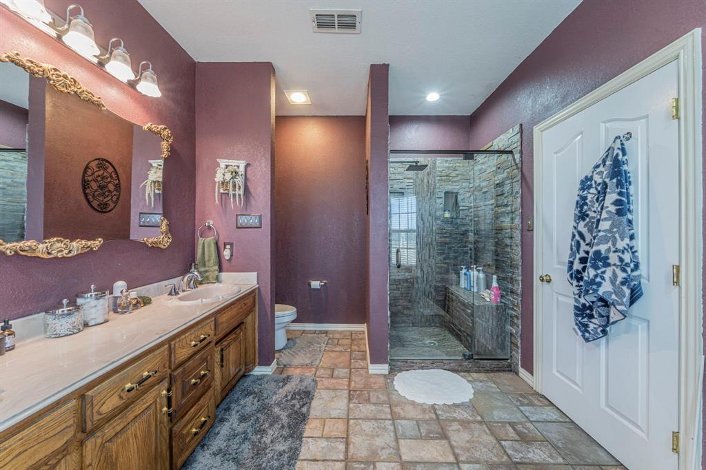 6438 Farm To Market 4 Godley, TX 76044 - Photo 17 of 32 a bathroom with a sink a toilet a mirror a vanity and shower