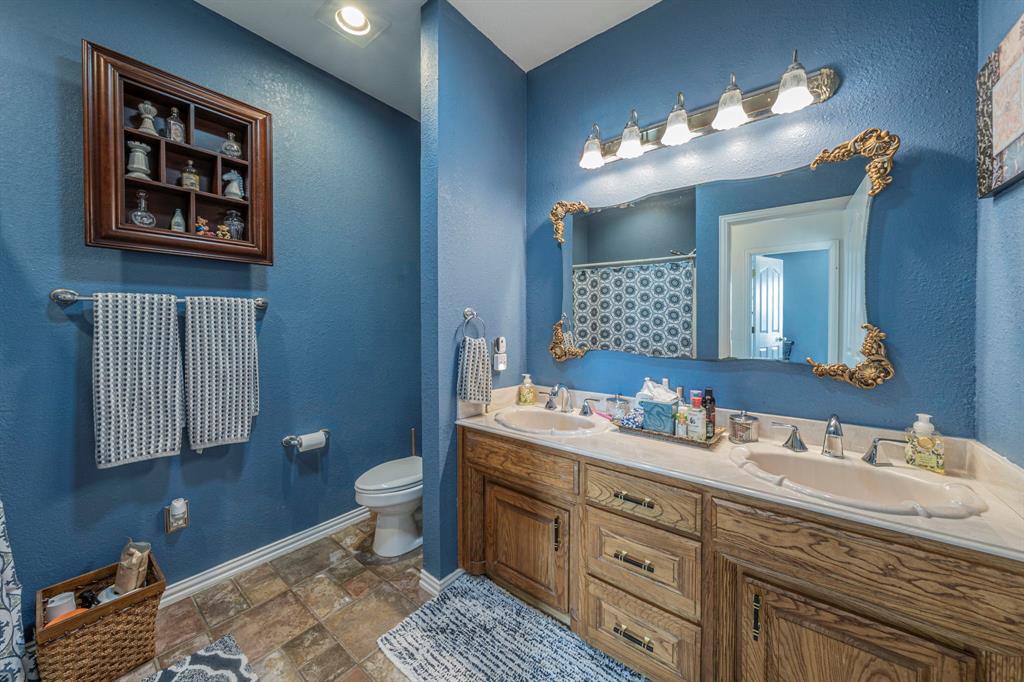 6438 Farm To Market 4 Godley, TX 76044 - Photo 20 of 32 a bathroom with a toilet a sink and mirror