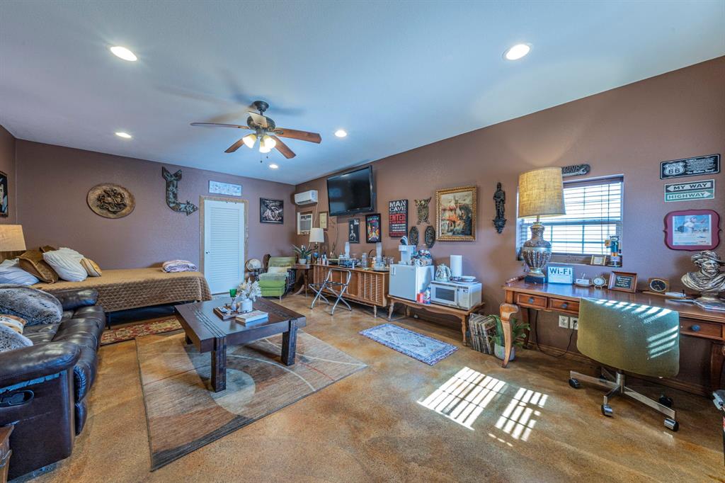 6438 Farm To Market 4 Godley, TX 76044 - Photo 21 of 32 a living room with furniture a piano and a bookshelf