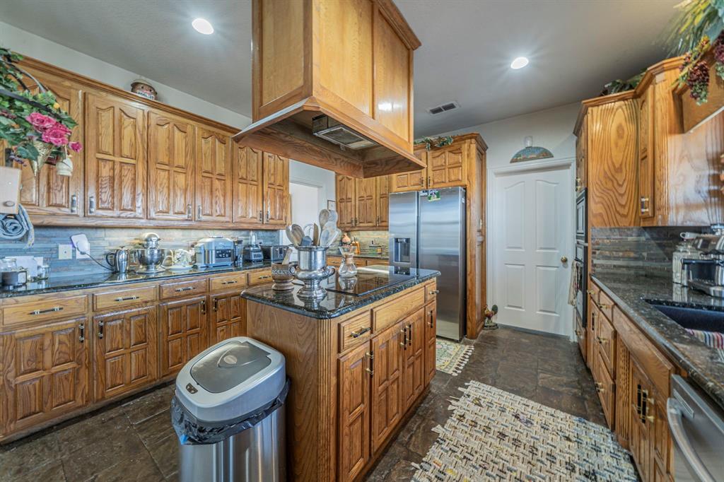 6438 Farm To Market 4 Godley, TX 76044 - Photo 8 of 32 a kitchen with stainless steel appliances granite countertop a sink a stove and cabinets