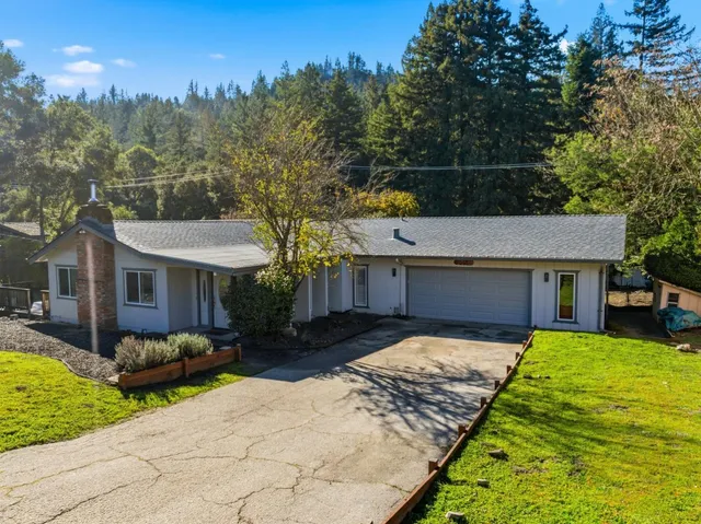 a view of house with backyard and trees