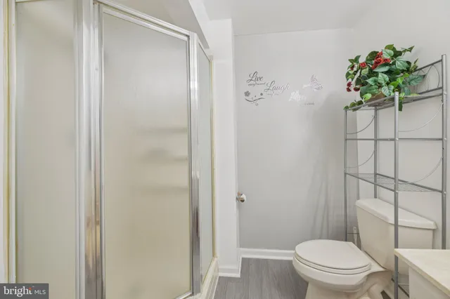 a white toilet sitting next to a shower