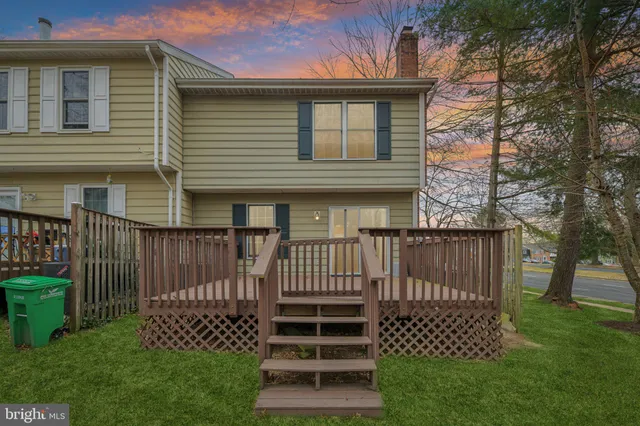 a view of a house with a yard and a bench