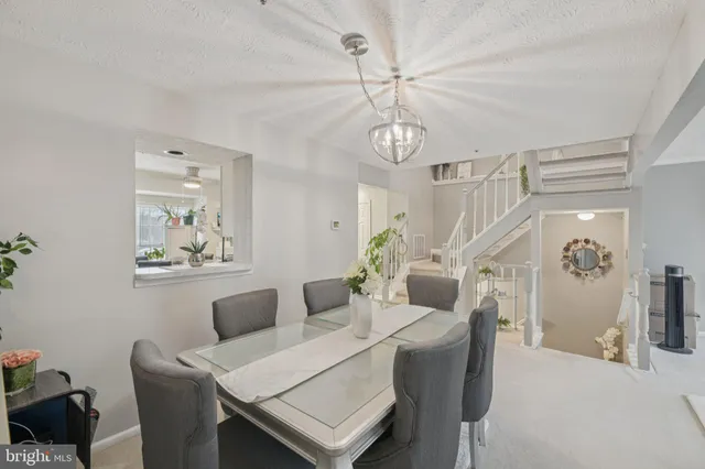 a view of a dining room with furniture and a chandelier fan