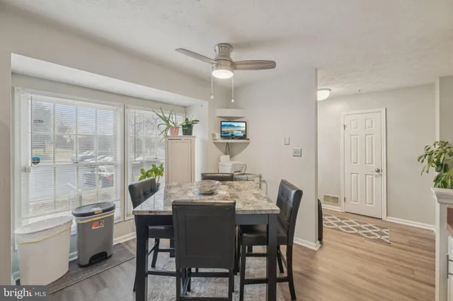 a dining room with furniture a chandelier and wooden floor