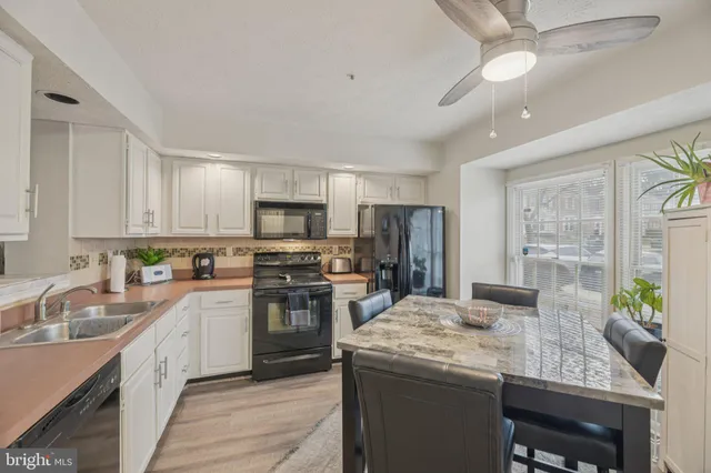 a kitchen with granite countertop a sink appliances cabinets and a counter top space