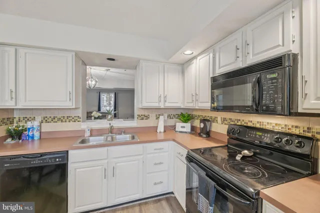a kitchen with stainless steel appliances granite countertop a stove a sink dishwasher and cabinets with wooden floor