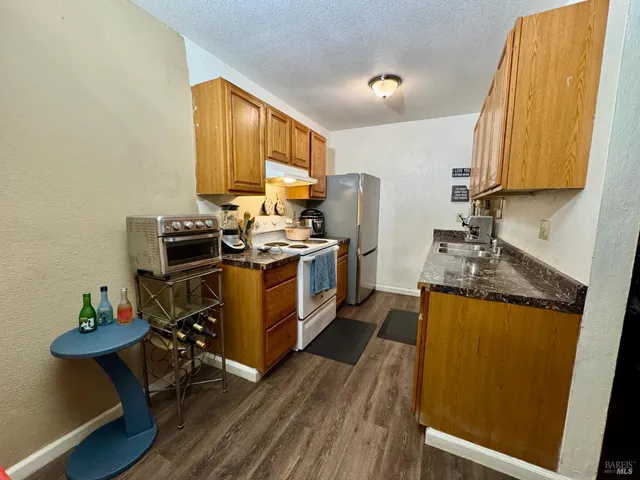a kitchen with stainless steel appliances a stove a sink dishwasher and a refrigerator