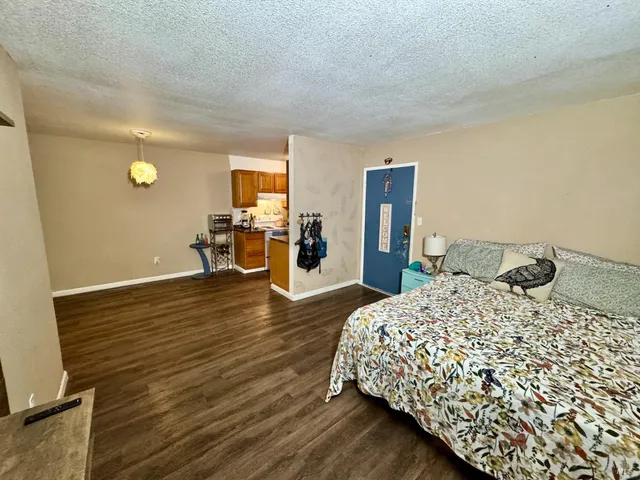 a bedroom with a bed and wooden floor