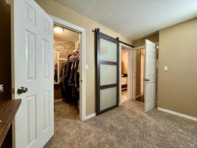 a view of a hallway with closet and stairs