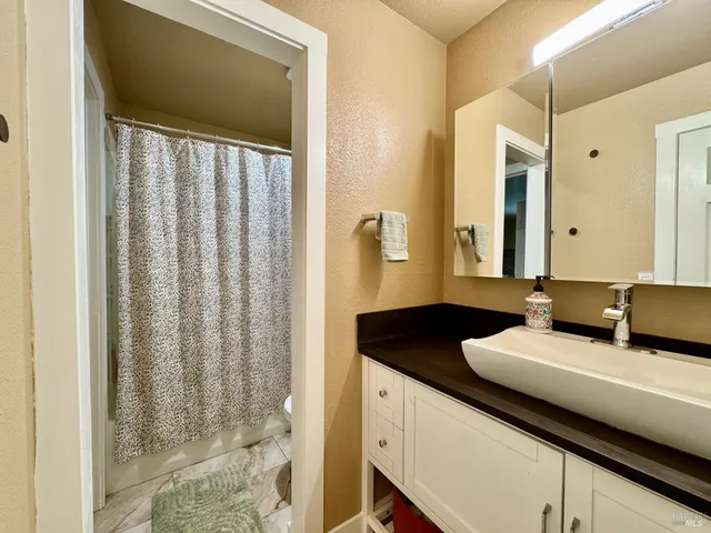a bathroom with a granite countertop sink and a mirror