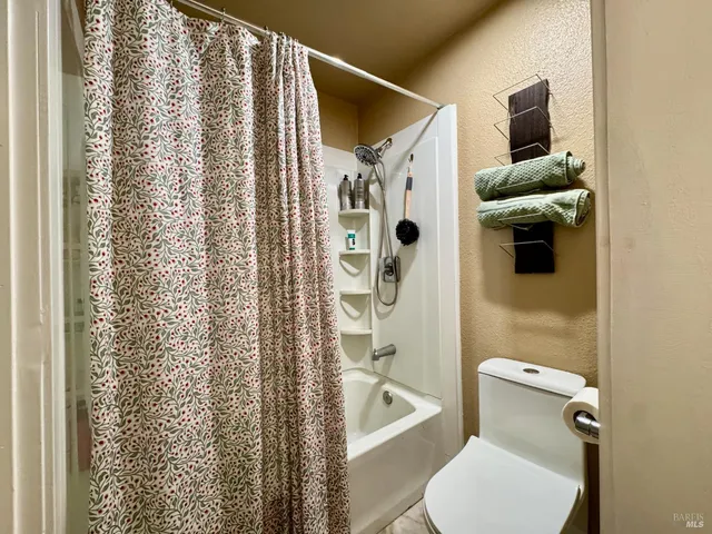 a bathroom with a toilet and a shower