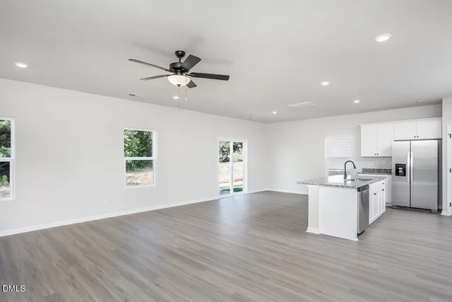 a view of a kitchen with a sink wooden floor and stainless steel appliances