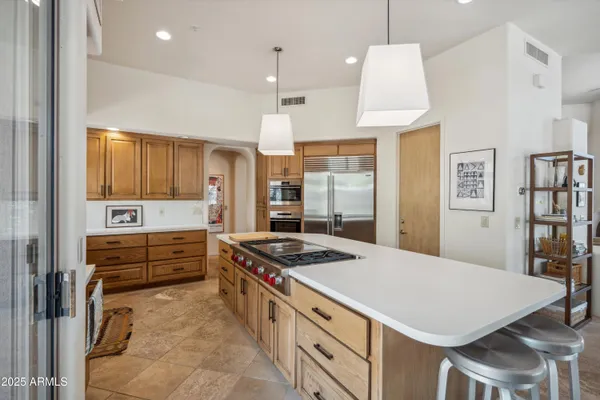 a kitchen with stainless steel appliances a stove a refrigerator and cabinets