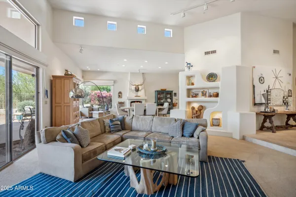 a living room with furniture wooden floor and a large window