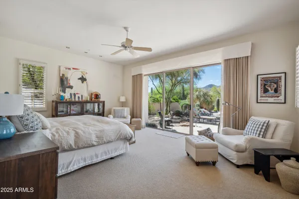 a bedroom with a bed couch and a large window