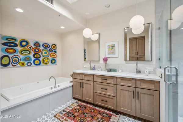 a bathroom with a double vanity sink mirror and bathtub