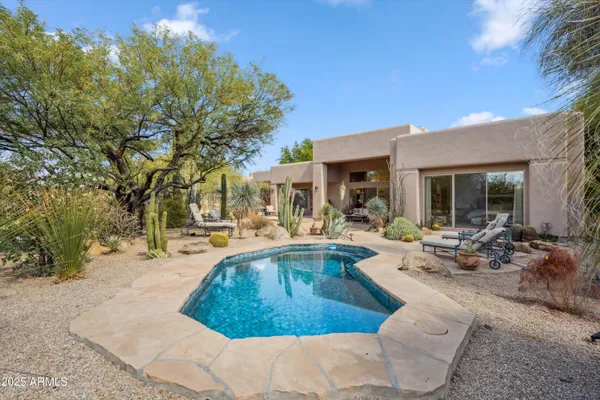 a view of a house with swimming pool and sitting area